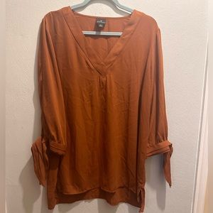 Burnt orange top with ties on end of sleeve